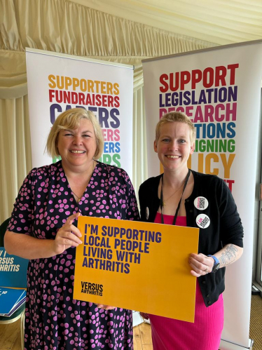 Jane standing with a representative of 'Versus Arthritis'